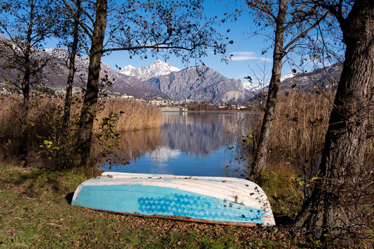 Italian alpine lake with the mountains in the background and a boat resting on a fine winter day