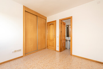 room with oak carpentry, built-in wardrobe with sliding doors and en suite bathroom