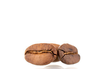 Three fragrant freshly roasted coffee beans, close-up, isolated on white.