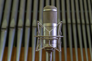 Condenser studio microphone in a Catholic church against the background of organ pipes. Recording...