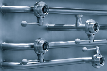 Pipelines from stainless steel, a system for pumping liquids or milk for the food industry. Abstract industrial background.