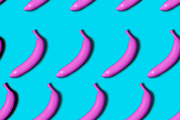 Seamless pattern of pink 3D rendered bananas on blue background with shadow in vaporwave style.