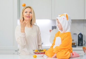 Mom and little daughter are preparing breakfast in the kitchen