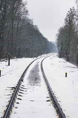 Bahnschienen die durch eine Winterlandschaft f&uuml;hren