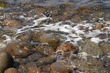 Obraz premium 岩の海岸で透き通った海水の波打ち際