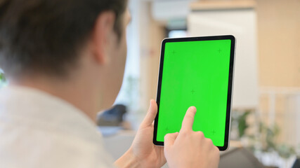 Young Man Using Tablet with Green Chroma Screen
