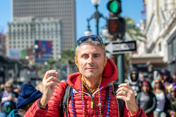 Happy man with colorful beads at Mardi Gras carnival parade event.