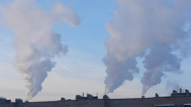 Thick smoke billows from the chimneys in the middle of the city