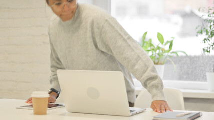 African Woman Coming Back Opening Laptop in Office