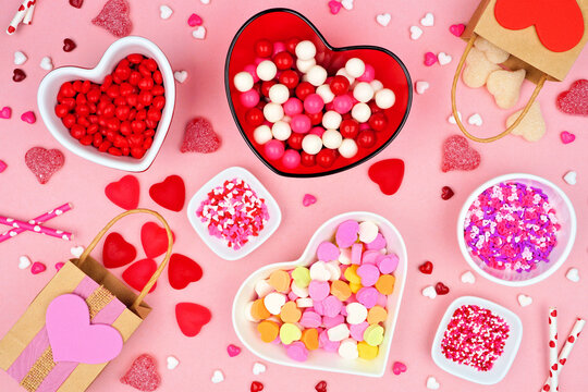 Valentines Day table scene with a variety of candies. Top view over a pink background. Love and hearts theme.