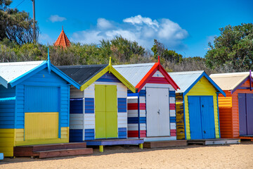 Fototapeta na wymiar Colorful huts in Brighton Beach on a sunny morning, Australia.