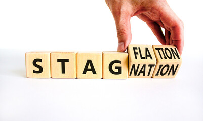 Stagflation or stagnation symbol. Businessman turns cubes, changes the word stagnation to stagflation. Beautiful white table, white background, copy space. Business, stagflation or stagnation concept.