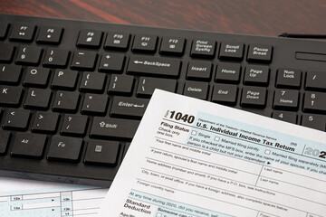 Income tax return and computer keyboard. Online filing, tax software and e-file concept.