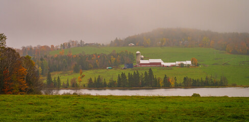 farm along river on rainy day in autumn
