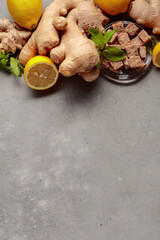 Ingredients for ginger tea on a gray concrete table.