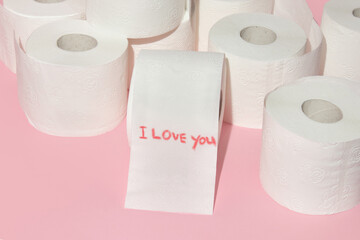 Valentines day creative layout with toilet paper rolls and handwritten message I love you on pastel pink background. 80s or 90s retro fashion aesthetic love concept. Minimal romantic idea.