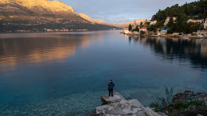 Minimalism sunset in Korcula Island with a man in rocks, Croatia