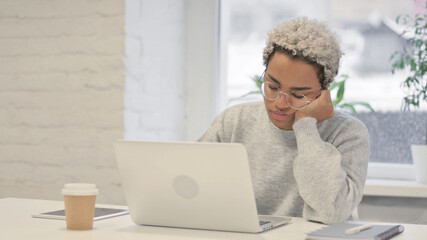 Tired African Woman taking Nap While Sitting in Office with Laptop