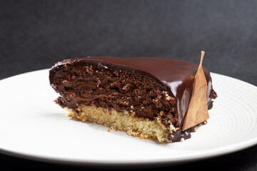 Homemade mousse cake with mirror chocolate coating decorated with chocolate triangles painted with edible gold, concept of lactose-free homemade dessert