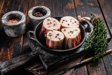 Fresh Raw beef Marrow bones in pan for cooking broth. Wooden background. Top view