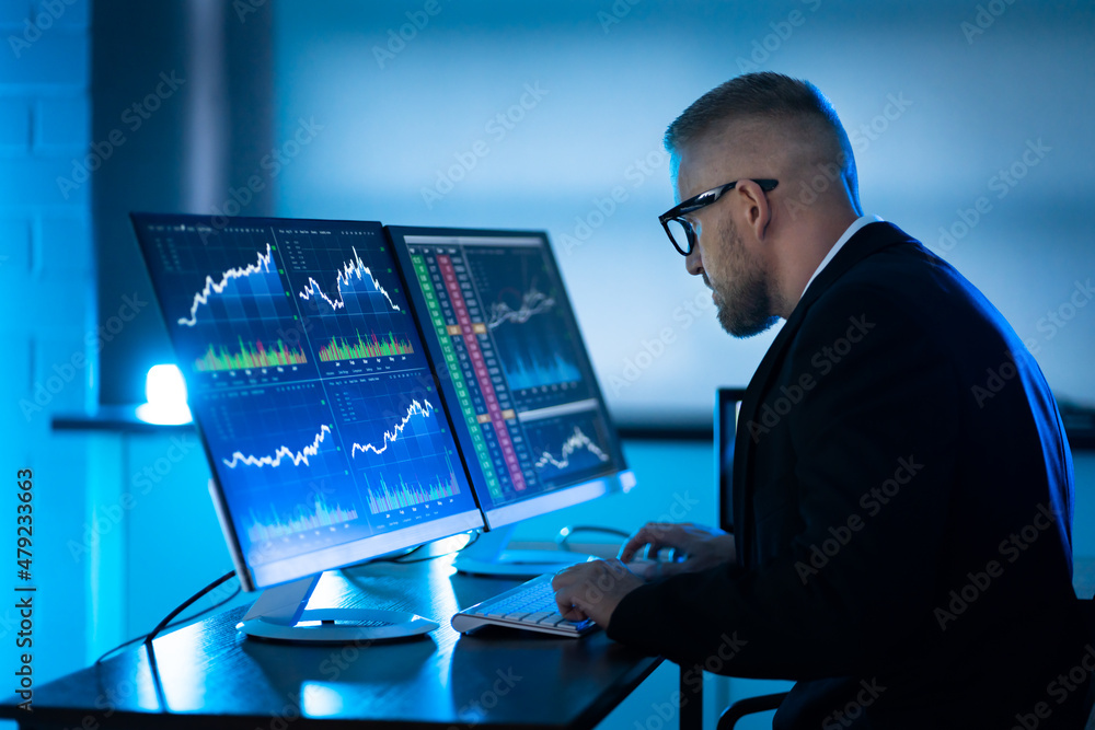 Fototapete Stock Trader Man Using Multiple Computers