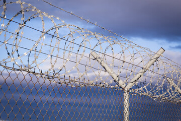 Fence with barb wire rolls on top