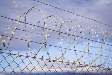 Closeup focus view of NATO barb wire with sharp and dangerous razor blades	