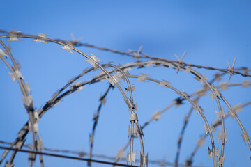 Closeup focus view of NATO barb wire with sharp and dangerous razor blades	