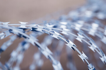 Closeup focus view of NATO barb wire with sharp and dangerous razor blades 