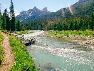 clear teal blue river winds through the mountains on a sunny day