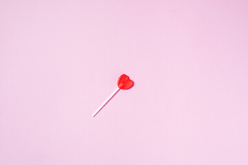 Heart shaped lollipops on purple background