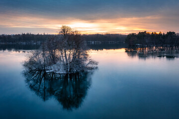Fototapeta na wymiar Aerial landscape of a wintery lake at sunset. Poland