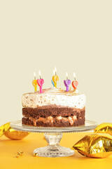 Stand with tasty birthday cake and balloons on table