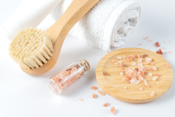 Fototapeta na wymiar Skin care products - body or face brush and cream tube on white towel - spa and relaxation products