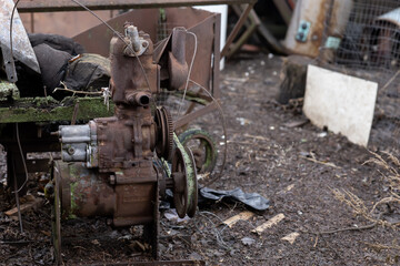 an old rusty motor is scrap metal on the farmyard