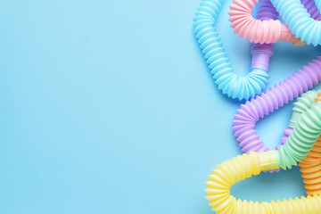 Different colorful Pop Tubes on blue background