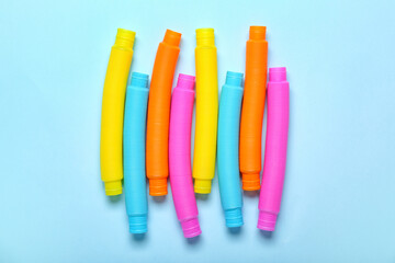 Different colorful Pop Tubes on blue background