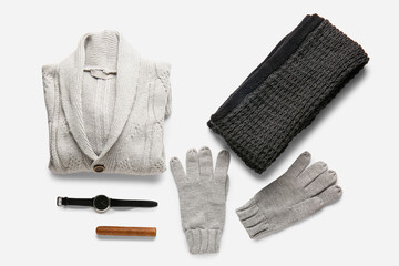 Knitted male sweater, scarf, gloves, wristwatch and cigar on white background