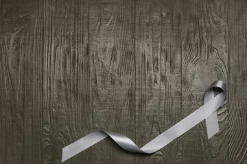 Parkinson's awareness ribbon on wooden background, top view