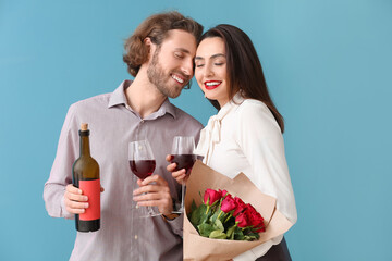 Happy young couple with wine and flowers on color background. Valentine's Day celebration