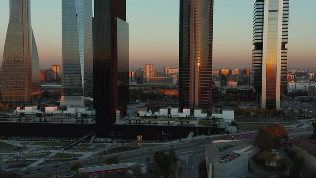 Forwards fly towards modern skyscrapers in Cuatro Torres Business area at sunset time. Row of high rise office buildings.