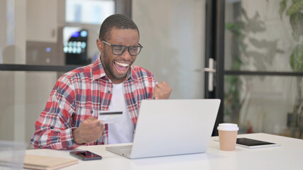 Fototapeta na wymiar African Man making Successful Online Payment on Laptop