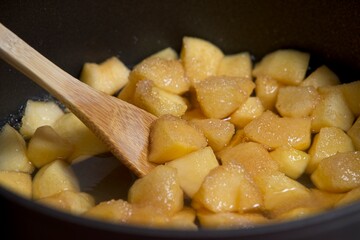 Apple pieces cooking in casserole with sugar