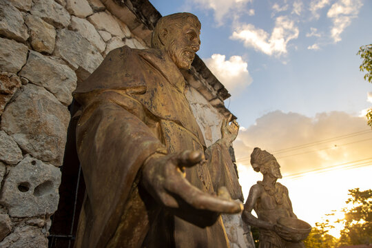 Statues representing a priest speaking with Maya people on the steps of a Mayan ruin seen on the island of Cozumel in Mexico