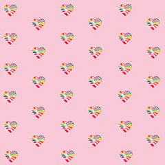 Pattern made of heart shaped candies. Colorful lollipops on pastel light pink background. Creative Valentine's day flat lay concept.