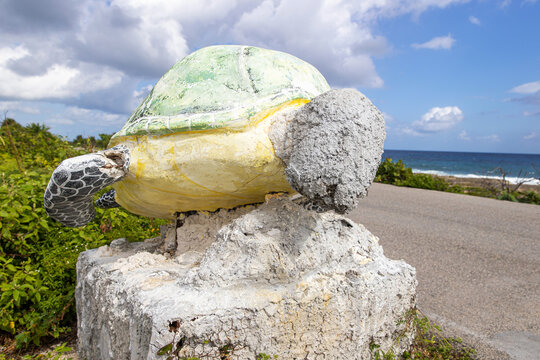 An old decaying stone statue of a sea turtle with paint fading in the bright Mexican sun seen on the south side of Cozumel, Mexico in Quintana Roo