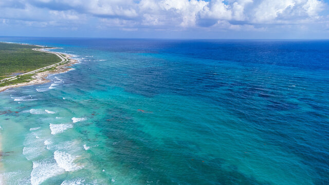 Aerial view captured by drone of beautiful turquoise blue ocean water in the Caribbean sea clear with a view of the coral reef surrounding tropical island Cozumel, Mexico in Quintana Roo.