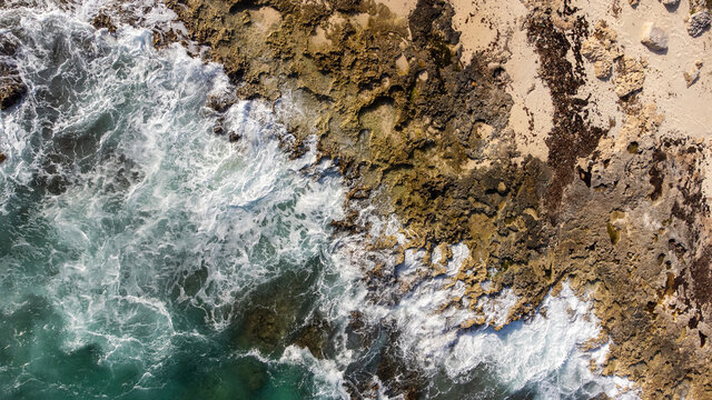 Aerial view captured by drone showing the power of the Caribbean sea waves. The ocean water crashes into the limestone shore on the beach of tropical island Cozumel, Mexico in Quintana Roo.