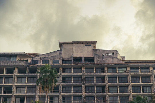 An abandoned and empty resort hotel on a tropical island beach shows decay and age