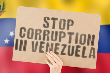 The phrase " Stop Corruption in Venezuela " on a banner in men's hand with blurred Venezuelan flag on the background. Forbidden. Prevent. Wealth. Offence. Corruptness. Economy. Corruptible. Political